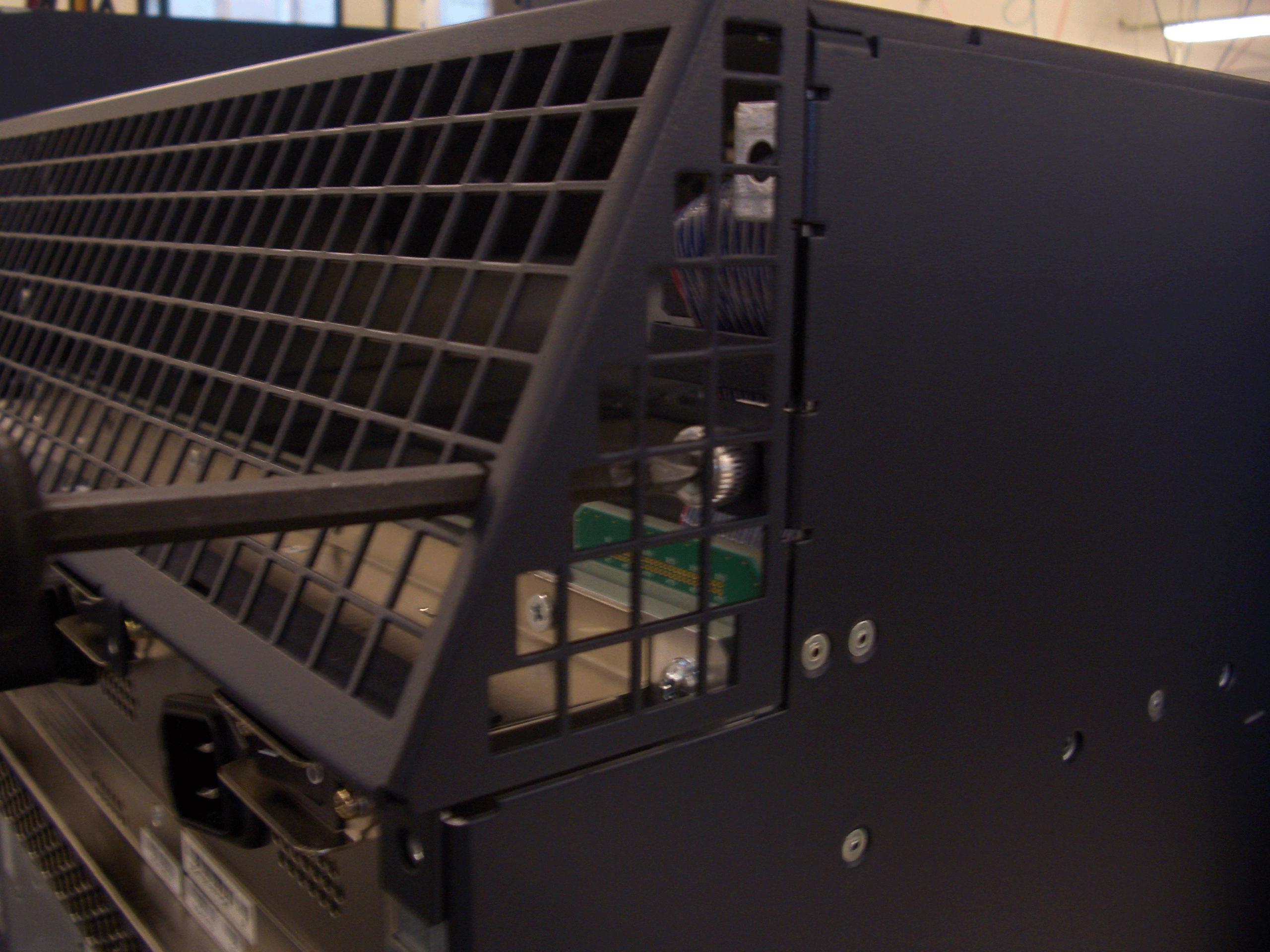Close-up of a server's vented panel showing internal circuit boards and wiring for airflow and cooling.