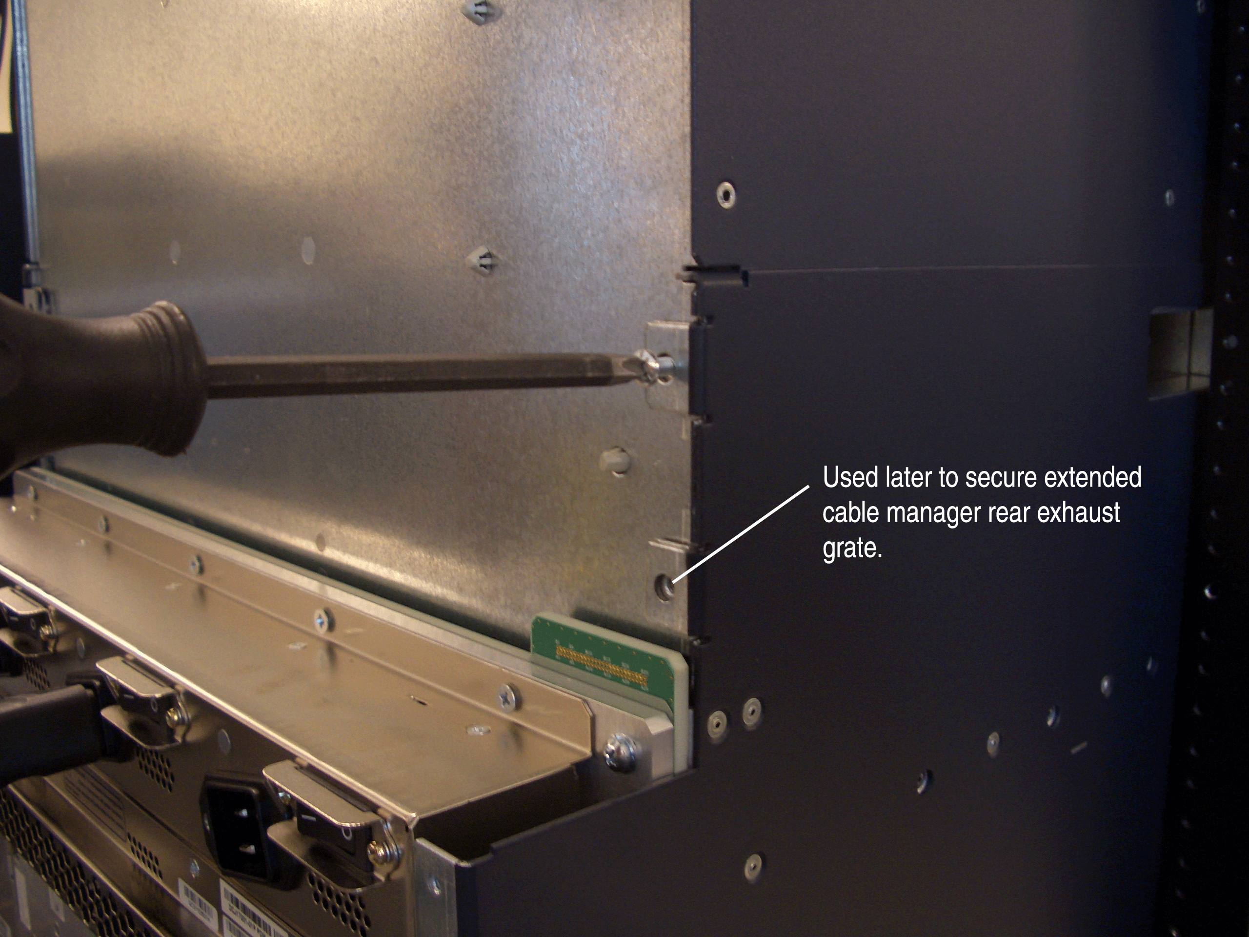 Server equipment being adjusted with a screwdriver to secure a component for cable management and cooling.