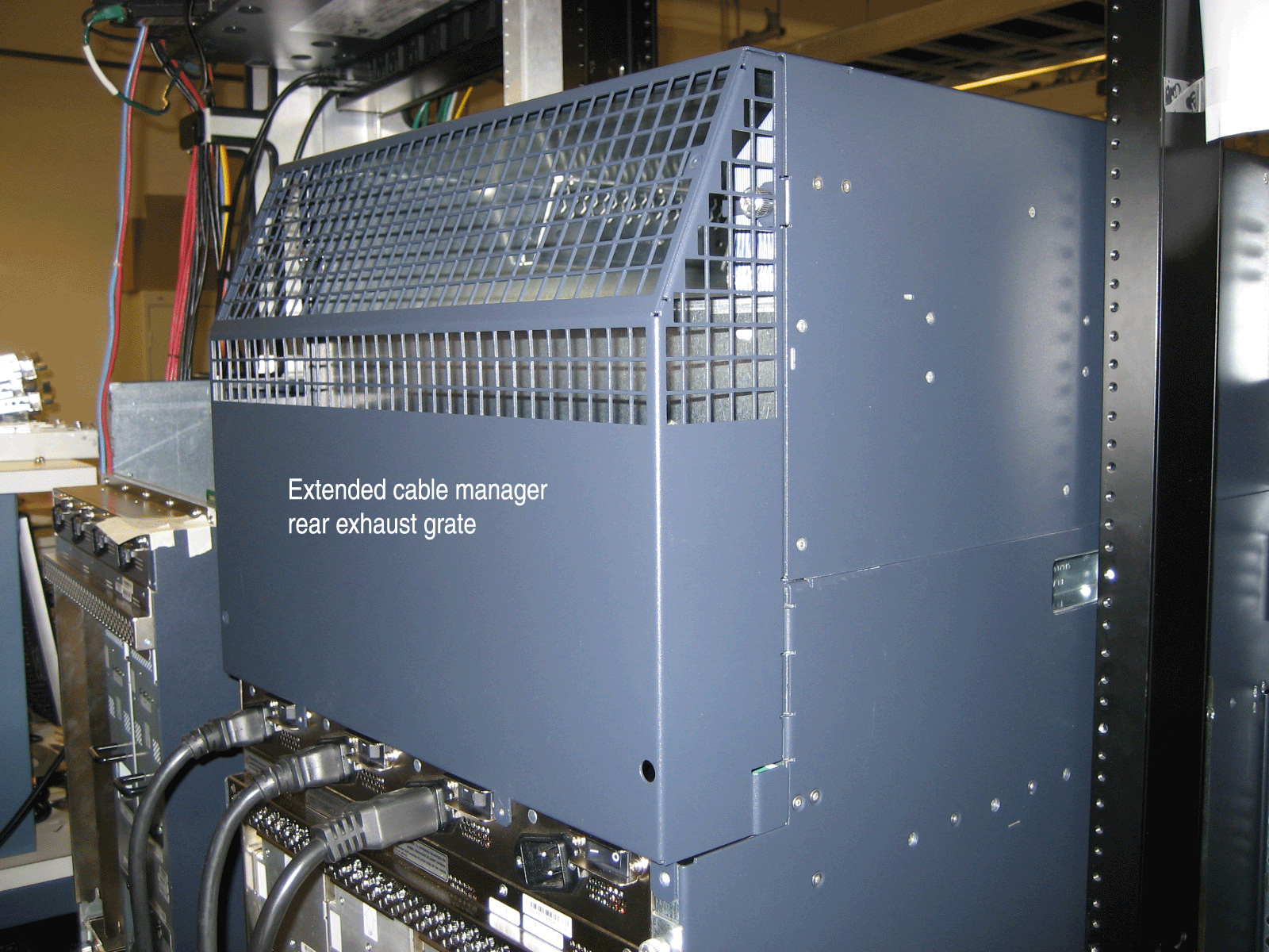 Extended cable manager with rear exhaust grate in a server rack managing cables and facilitating cooling in a data center.