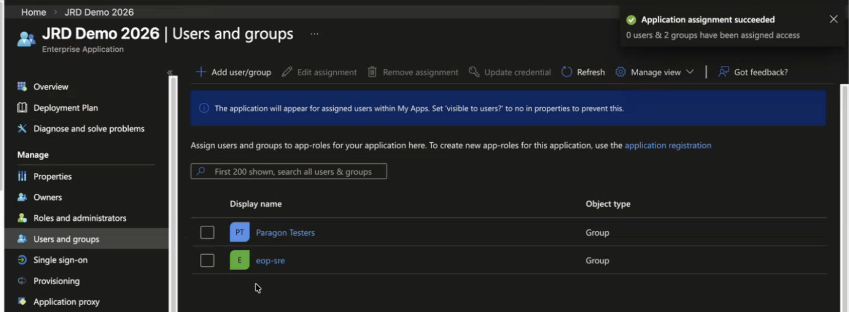 Managing app interface for JRD Demo 2026. Users and groups section lists Paragon Testers and eop-sre assigned with Group object type. Success notification confirms application assignment.