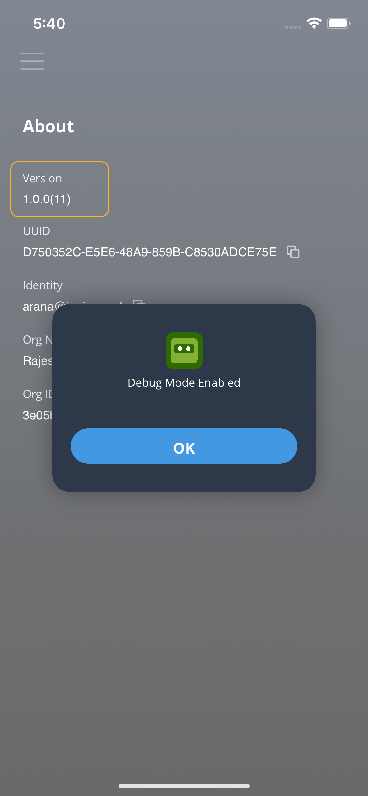 Mobile app About screen showing app version 1.0.0, UUID, identity email, organization name, organization ID, and Debug Mode enabled pop-up with OK button.