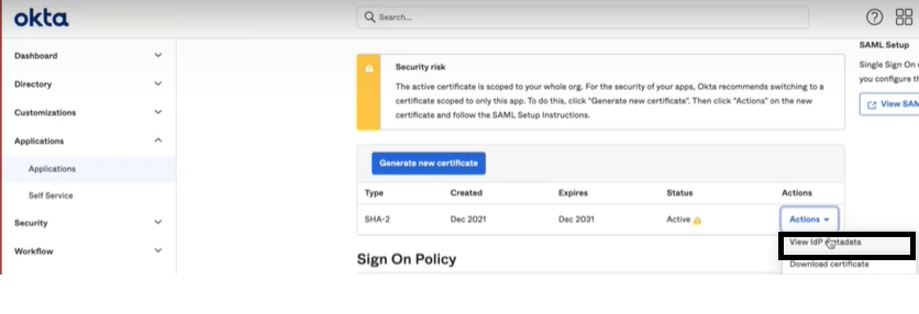 Okta admin interface showing Applications section for configuring SSO with SAML. Security risk warning to switch certificate for better security. Certificate details: Type SHA-2, Created Dec 2021, Expires Dec 2031, Status Active. Generate new certificate button available. Actions dropdown with View IdP metadata highlighted.